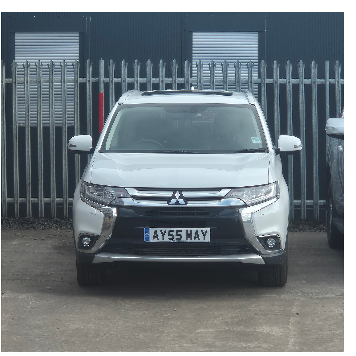 Front view white Mitsubishi SUV parked