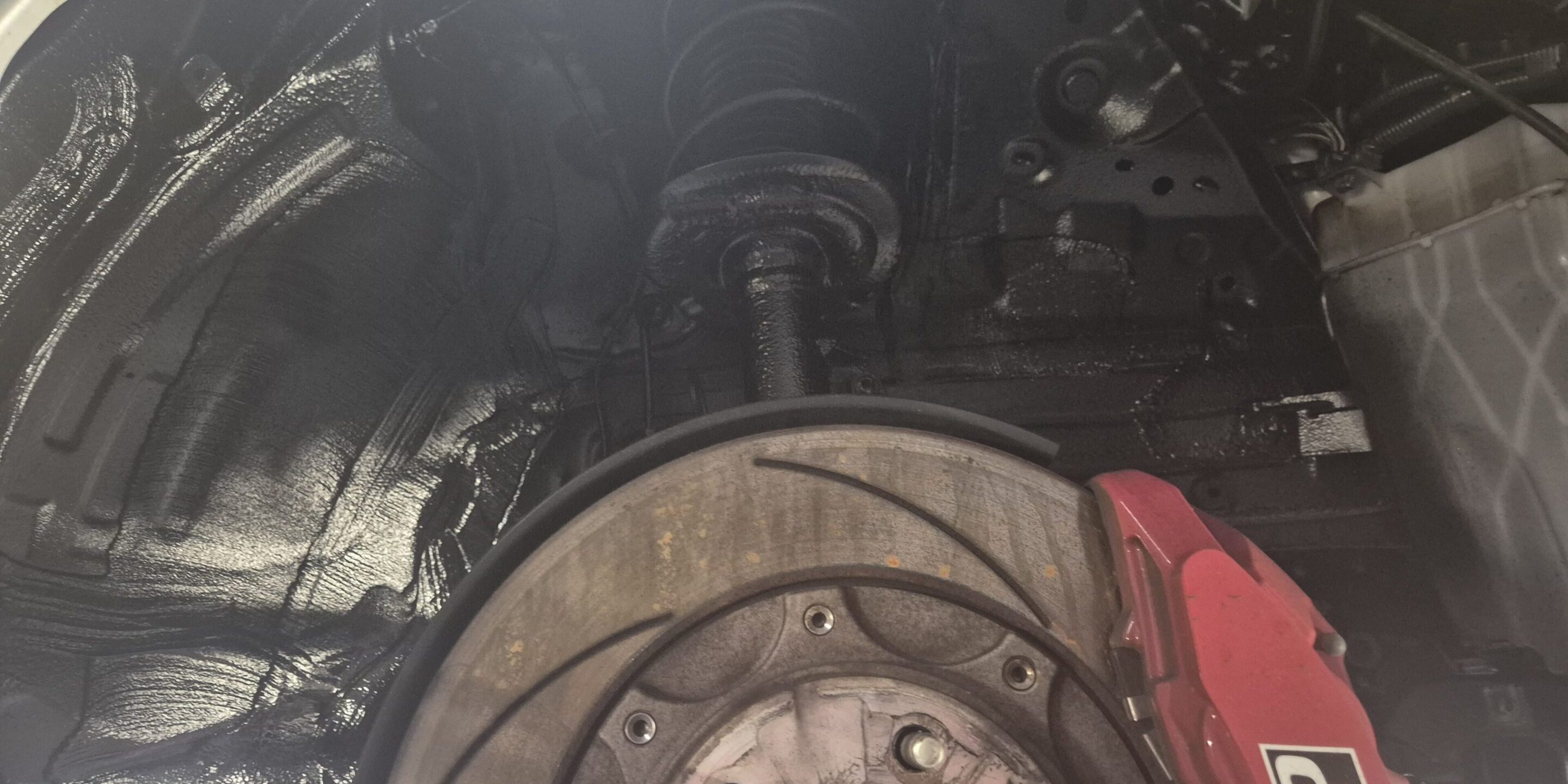Exposed brake rotor with red GR caliper